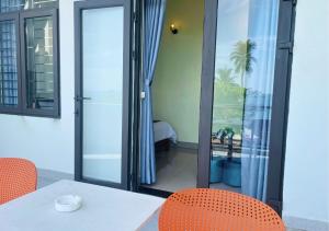 a room with a table and chairs and a balcony at Sontra Sea Hotel in Danang