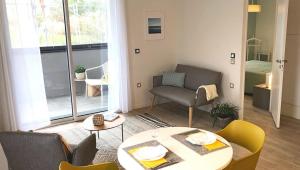 a living room with a table and a chair at Oh Activ Les Ponts-de-Cé in Les Ponts-de-Cé