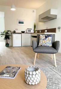 a living room with a chair and a table at Oh Activ Les Ponts-de-Cé in Les Ponts-de-Cé +6 photos