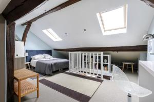 a attic bedroom with a bed and a crib at Paris - Cosy Duplex près des Champs Elysées in Neuilly-sur-Seine