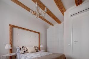 a bedroom with a bed and a chandelier at la Maison de Trieste Suite garage in centro 5 persone vicino Piazza Unità in Trieste