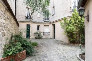 an empty courtyard of an apartment building with a gate at Paris - Cosy Duplex près des Champs Elysées in Neuilly-sur-Seine