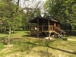 蒙尼斯帕勒特Les Cabanes de Lara的树林里的一间小屋，前面停着一辆摩托车