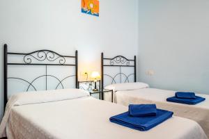 2 posti letto in una camera con asciugamani blu di Casa Rural Rinconada a La Rinconada de la Sierra