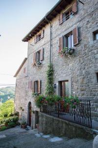 un vieux bâtiment en pierre avec des fleurs dessus dans l'établissement The house of Gostina, à Santa Fiora