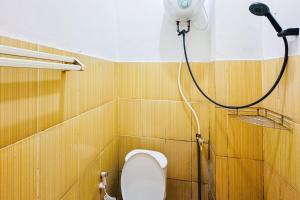 a bathroom with a toilet and a shower at Penginapan Dison RedPartner in Bekasi