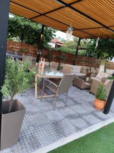 a patio with a table and chairs under an umbrella at Haus Riviera in Asprovalta