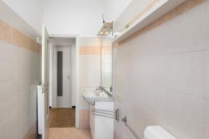 Un baño blanco con lavabo y espejo. en Casa Marina, en Savona