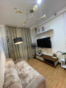 Una sala de estar con un sofá y un televisor de pantalla plana. en budget staycation, en Davao City
