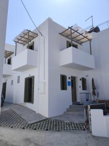 a white building with stairs on the side at Galani Mirtia Guest House in Skiros