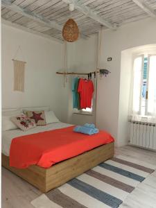 a bedroom with a bed with a red blanket at Casa Martina in Arcola
