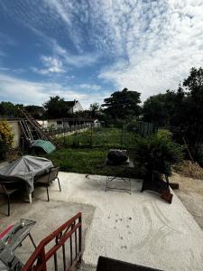 a patio with a bench and a tree on it at Maison fraîchement rénovée in Aulnay-sous-Bois