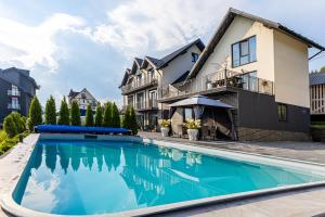 a swimming pool in front of a house at Comfort House in Bukovel