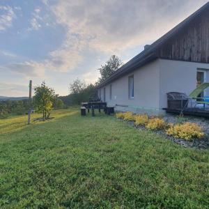 a white house with a picnic table in a yard at Dom wakacyjny u Beaty nad Jeziorem Rożnowskim in Bartkowa-Posadowa