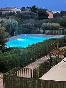 a large blue swimming pool with a fence around it at Spacious Apartment in Realmonte, Sea View in Realmonte