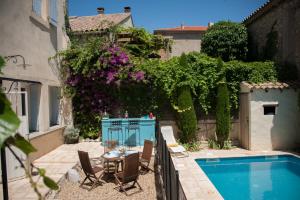 a patio with a table and chairs next to a pool at Maison Pelissier Bed and Breakfast with swemming pool in Cuxac-dʼAude