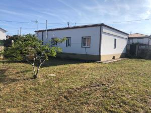 a small white house with a small tree in a yard at Rua de Vionta in Ribeira