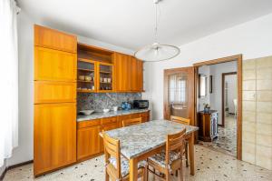 a kitchen with wooden cabinets and a table with chairs at Cozy Apartment near Venice with Balcony! in Campalto