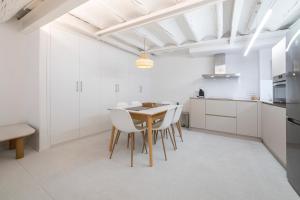 a kitchen with white cabinets and a table and chairs at VALERIA-DREAMS Loscos 3º in Zaragoza +8 photos