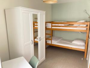 ein kleines Zimmer mit Etagenbetten und einem Schrank in der Unterkunft Les Chamois du Sancy in Le Mont-Dore