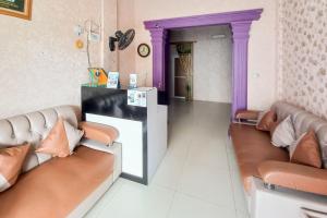 a living room with two couches and a purple doorway at Panam House Syariah RedPartner in Pekanbaru