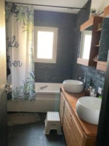 a bathroom with two sinks and a tub and a shower at Maison familial piscine près de bordeaux 2 chambres in Artigues-près-Bordeaux