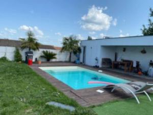 a swimming pool in a yard next to a building at Maison familial piscine près de bordeaux 2 chambres in Artigues-près-Bordeaux