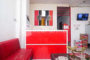 a red couch in a room with a red wall at Griya Jasmine Syariah Seturan RedPartner in Yogyakarta
