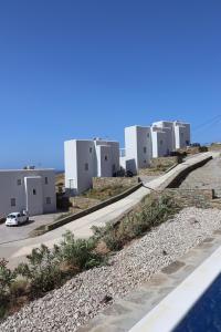 a row of white buildings on the side of a road at Antigoni Villas in Gavrio