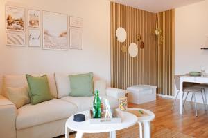 a living room with a white couch and a table at Modern & gepflegt, Süd-Terrasse, Parkplatz, Nähe DUS in Kaarst