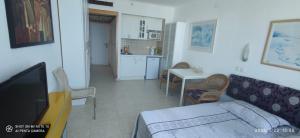a living room with a couch and a table and a kitchen at NetanyaCarmel in Netanya