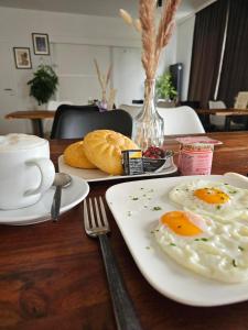 a table with plates of eggs and bread on it at Hotel Fuchs & Hase SELF CHECK IN in Rosegg