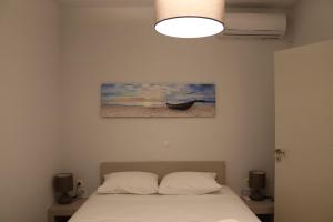 a bedroom with a bed and a picture of a boat at Antigoni Villas in Gavrio