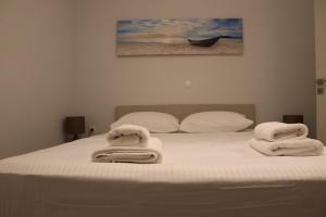 a bedroom with a bed with towels on it at Antigoni Villas in Gavrio