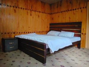 um quarto com uma cama grande com uma parede de madeira em Mountain View Guest House em Skardu