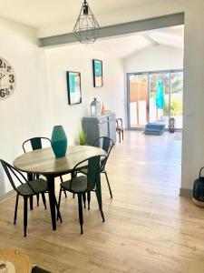 a dining room with a table and chairs at Charmante Maison Fourasine Centre-ville Jardin in Fouras