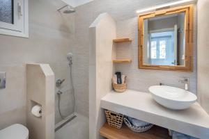 a bathroom with a sink and a toilet and a mirror at Perla's Luxury Apartments in Livadi +6 photos