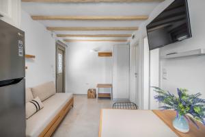 a living room with a couch and a tv at Perla's Luxury Apartments in Livadi