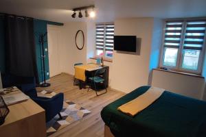 a bedroom with a bed and a desk and a table at Un studio dans maison familiale in Nordheim