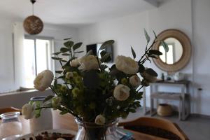 a vase filled with white flowers on a table at Antigoni Villas in Gavrio