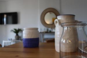 two glass vases sitting on a wooden table at Antigoni Villas in Gavrio