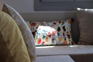 a couch with a pillow on top of it at Antigoni Villas in Gavrio