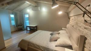 a bedroom with a large bed with a stone wall at VILA ŠKARLANIJA, Umag in Umag +37 photos