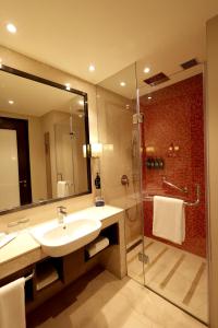 a bathroom with a sink and a shower at Ramada Plaza by Wyndham Lucknow in Lucknow