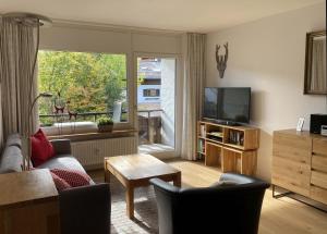 a living room with a couch and a television at Haus Obermaiselstein in Obermaiselstein