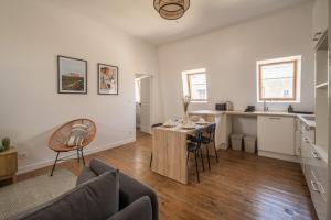 Una sala de estar con una mesa y una cocina. en Le Sicilien ~ Climatisation ~ Centre-ville, en Carcassone