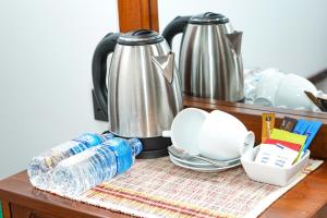 a table with a coffee pot and plates and water at Nature's Retreat in Dambulla