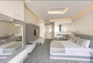 a hotel room with two beds and a mirror at White Line Boutique Hotel in Elazığ