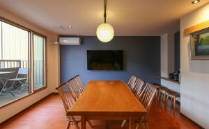 una sala da pranzo con tavolo e sedie in legno di Takayamaan 高山駅徒歩3分 古い町並み徒歩5分のベストロケーション 2バスルーム3寝室で広々快適 a Takayama