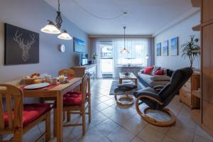a kitchen and living room with a table and a couch at Haus Obermaiselstein in Obermaiselstein
